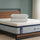 Pair of cooling memory foam pillows with breathable covers stacked on top of Zinus Ultra Cooling Green Tea Hybrid mattress, styled in bedroom with wood headboard and muted green wall.