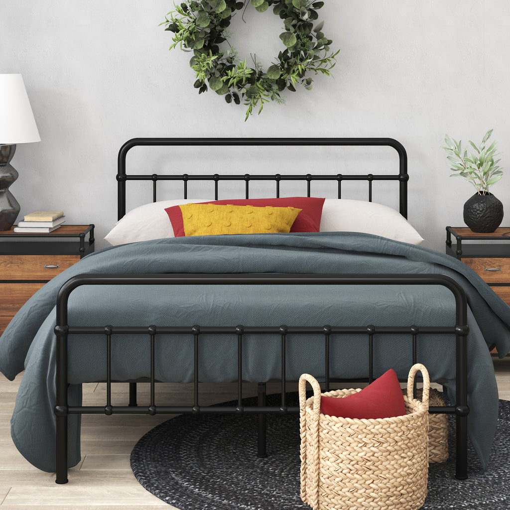 Styled bedroom featuring Zinus metal bed frame with headboard, dressed in blue bedding with decorative pillows and wicker storage basket beneath. Sturdy steel frame adds modern farmhouse charm while supporting queen or full mattresses with underbed storage space.