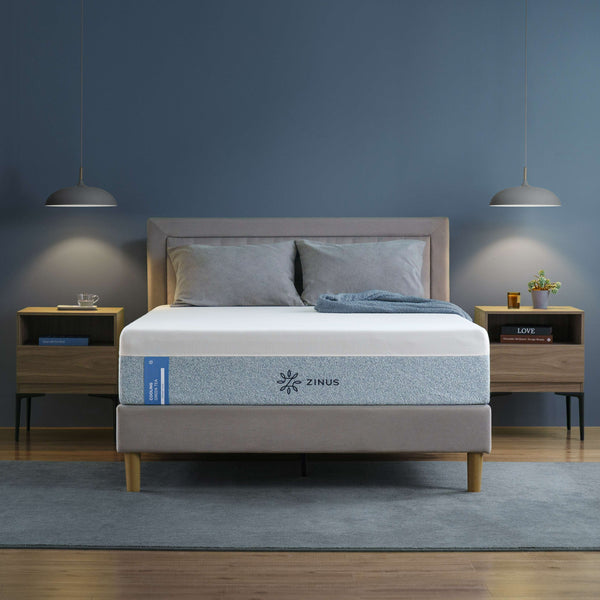 Zinus Cooling mattress with breathable cover on upholstered platform bed with gray headboard, styled in modern bedroom with wooden nightstand, gray bedding, and pendant light.