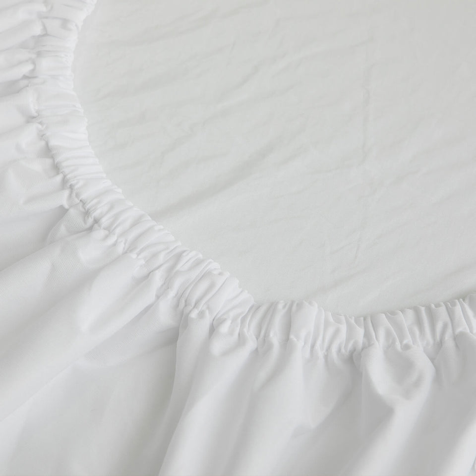 Close-up of Zinus TENCEL waterproof mattress protector in white, showing elasticized edge designed to secure tightly around a mattress. Smooth surface highlights breathable TENCEL fabric that protects against spills and allergens while maintaining comfort and extending mattress life.