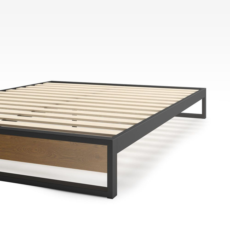 Close-up of Zinus Suzanne Metal and Bamboo Platform Bed Frame corner detail. Shows black steel frame construction, bamboo wood accent, and slatted mattress base. Sturdy design built for long-lasting durability and modern bedroom style