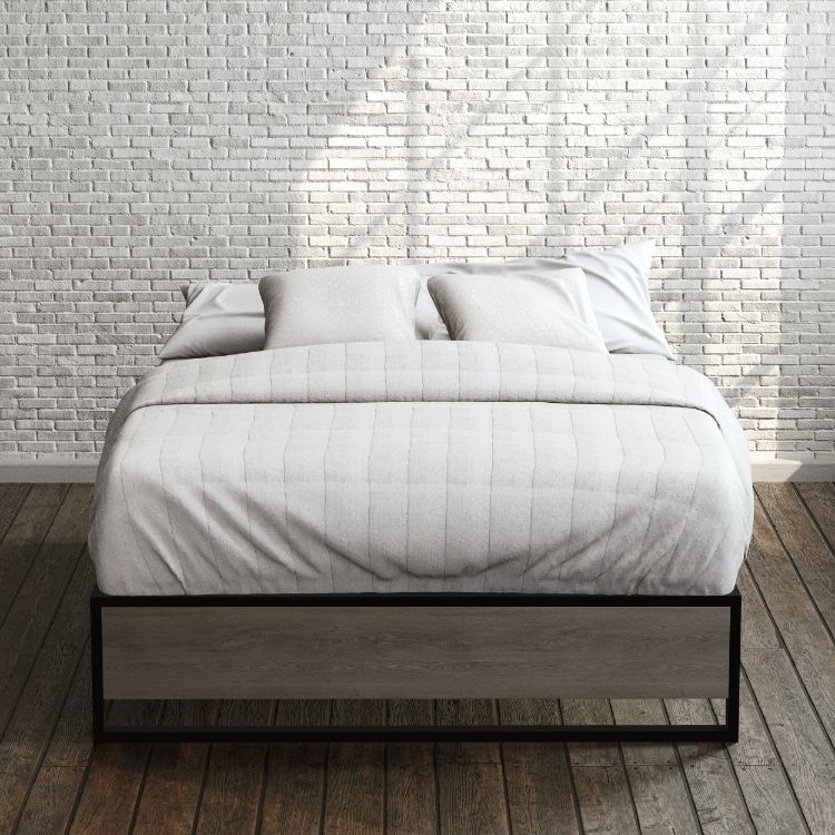 Zinus Suzanne Metal and Bamboo Platform Bed Frame in queen size, styled with white bedding against a brick wall backdrop. Black steel frame with bamboo accent panel and slatted base offers sturdy support and a clean, modern look for any bedroom.