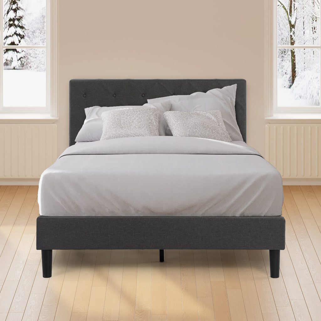 Zinus Upholstered Platform Bed Frame with gray tufted headboard styled with white bedding in a bright winter bedroom. Sturdy wooden slats provide reliable mattress support without a box spring. Sleek modern design with padded frame creates a cozy, durable centerpiece.